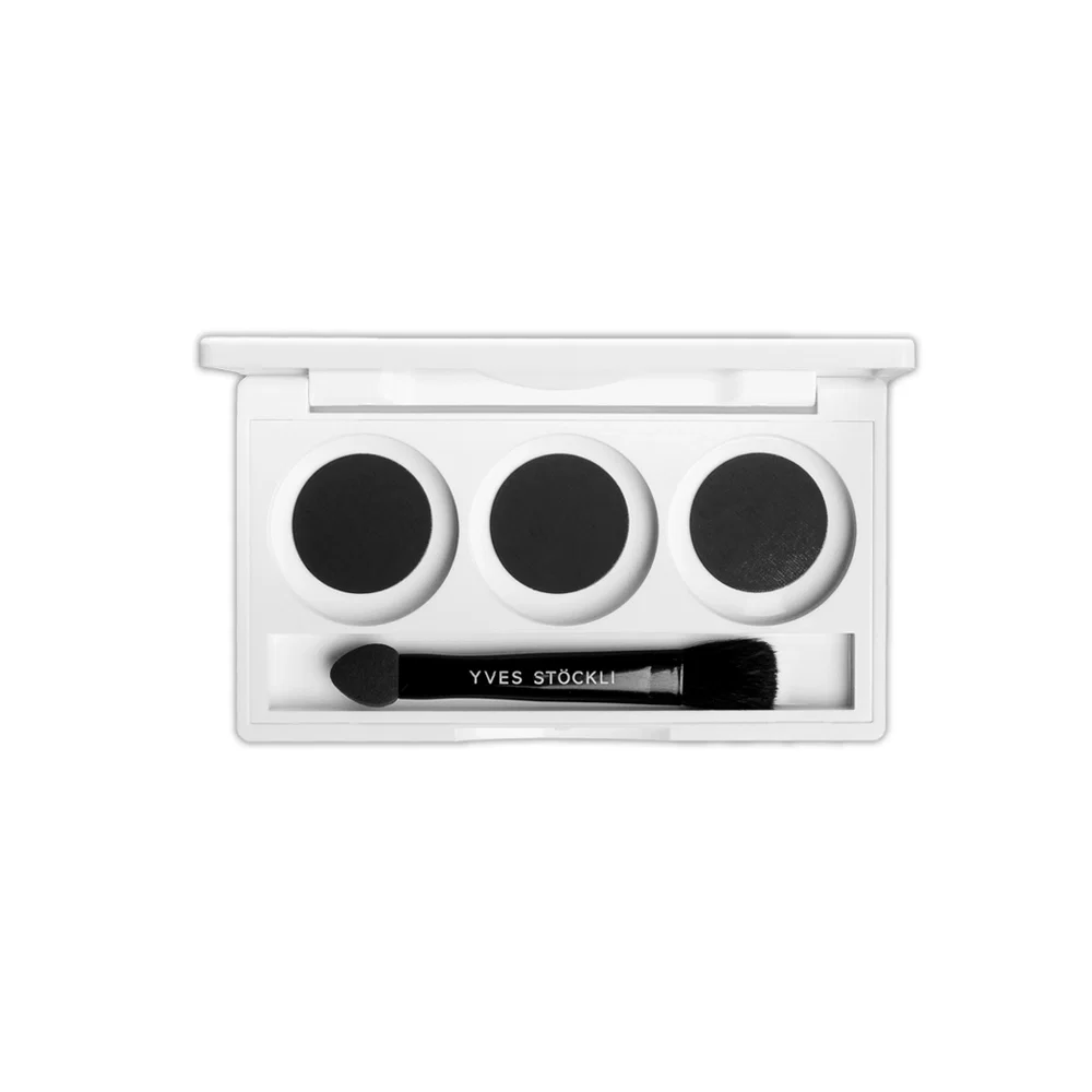Three black eyeshadows in a white palette with a black Yves Saint Laurent brush