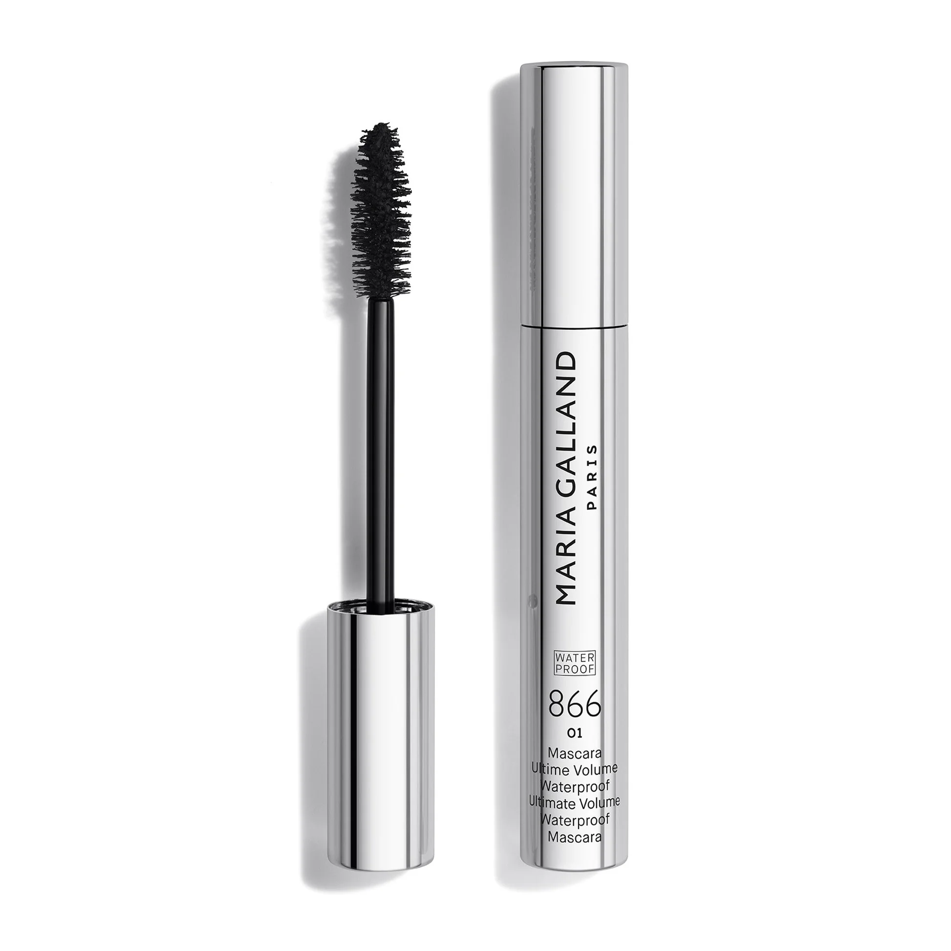 Mascara wand with black bristles beside a tall chrome mascara tube labeled MARC JACOBS PARIS, waterproof ultimate volume mascara.