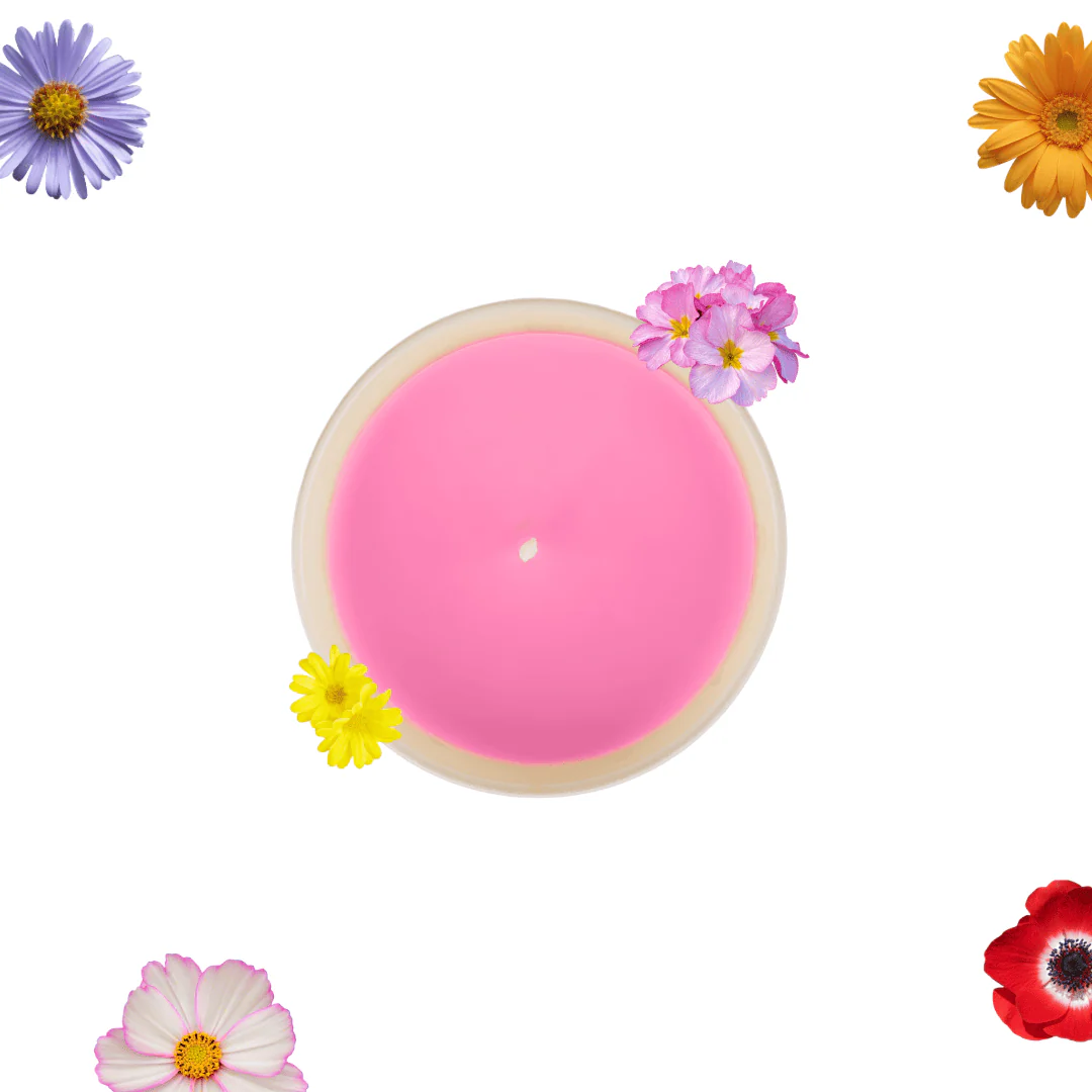 Pink round candle in a light holder with pink wax, decorated by small pink flower on top, surrounded by colorful flowers on white background (decorative)
