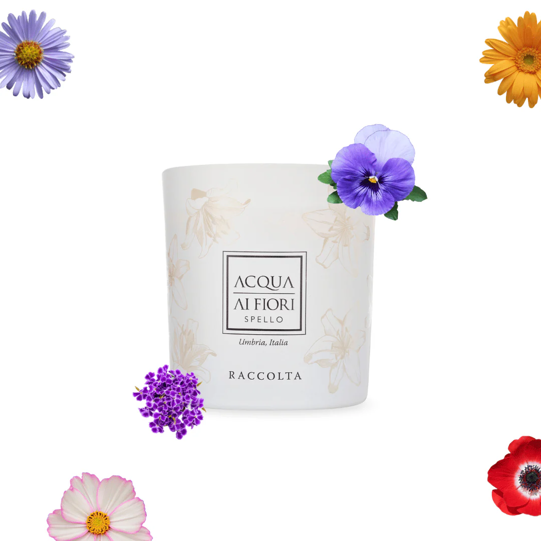 White ceramic cup with a subtle floral print and a centered label, surrounded by colorful flowers on a white background.