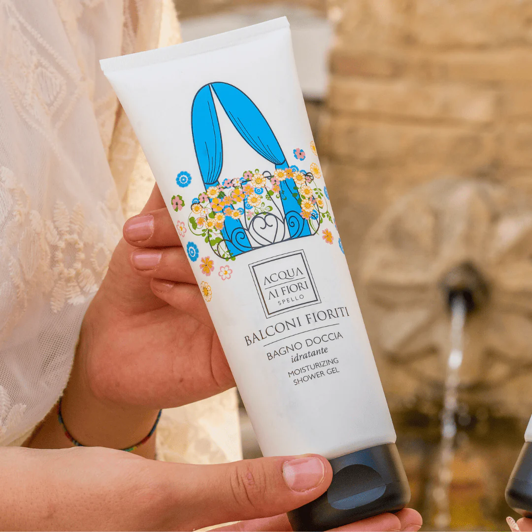 Hand holding a white tube of Balconi Fioriti moisturizing shower gel with a blue floral design and colorful flowers.