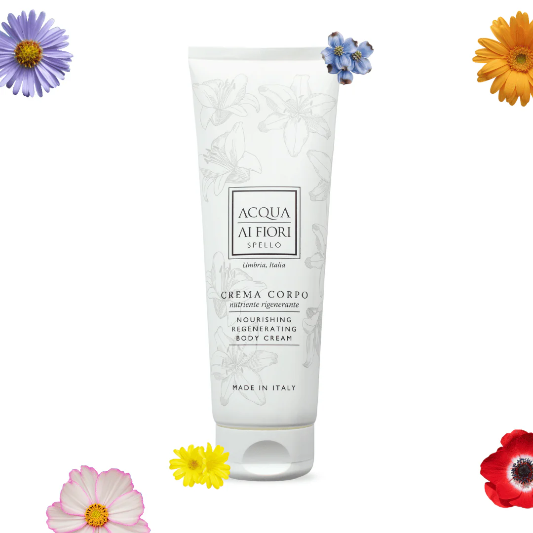 White tube of Acqua di Fiori Spello nourishing regenerating body cream with floral engravings, surrounded by colorful flowers for a fresh, botanical feel.