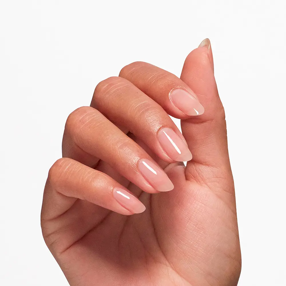 Close-up of a hand with almond-shaped nails painted pale pink glossy polish?