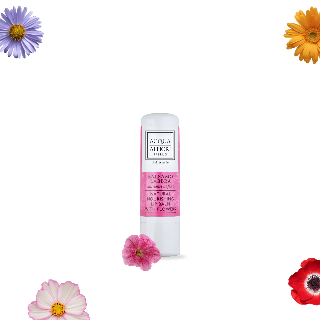 Lip balm tube with pink label reading 'Balsamo Labbra' and 'Natural Nourishing Lip Balm with Flowers', surrounded by colorful flowers on a white background